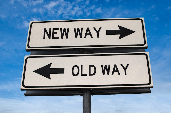 road signs with an "old way" sign pointing left and a "new way" sign pointing right