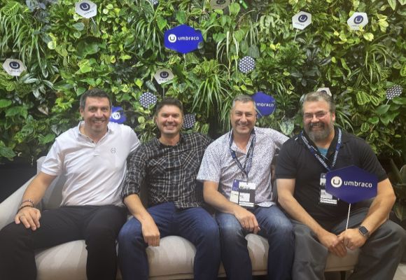 Four men sitting together at a tech conference